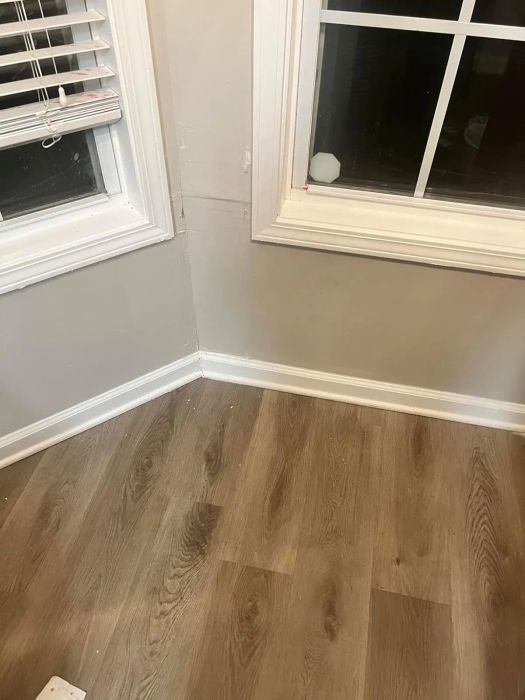 A corner of a room with wooden flooring is spotless, free from dust and wax buildup