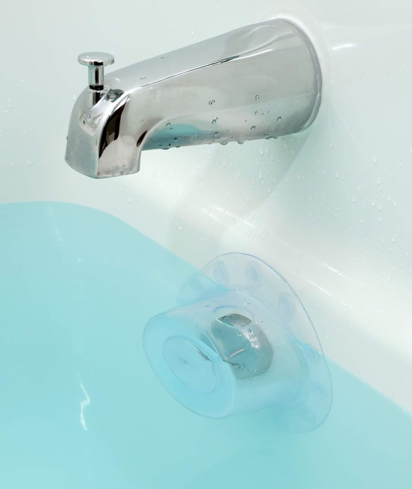 A bathtub with a drain cover neatly installed below the faucet.