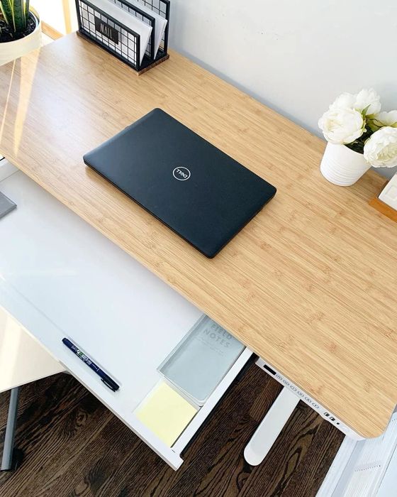 The same reviewer showcases their desk from the top, highlighting a convenient pull-out drawer.