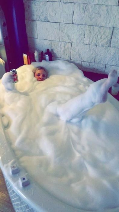 A reviewer covered in bubbles, enjoying a deep bath