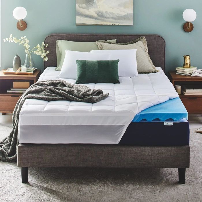 A mattress topper on a bed in a cozy room setting, displayed for purchase