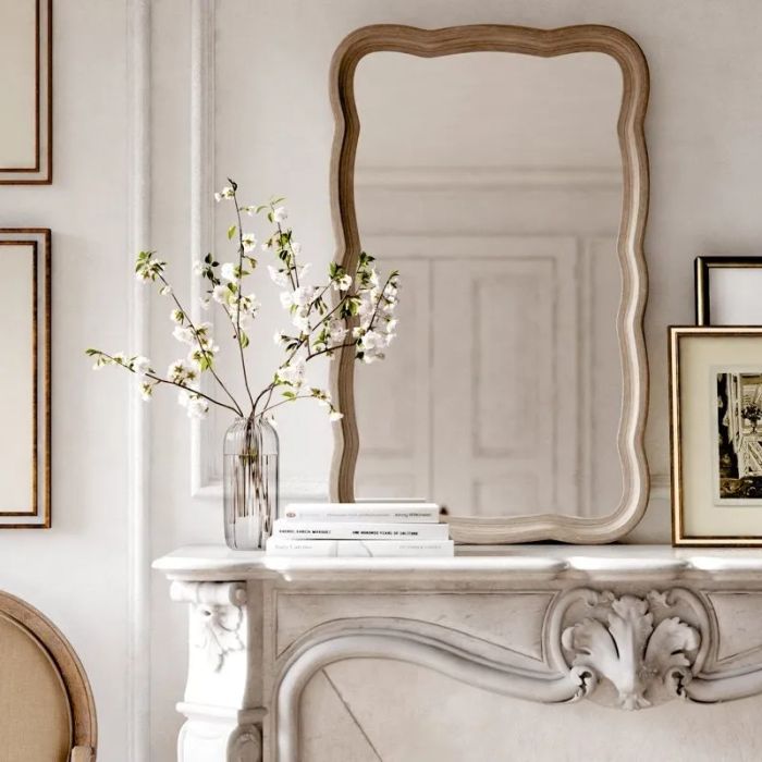 A sophisticated mirror with delicate scalloped edges, elegantly perched on a mantle, adding a touch of charm to the space.