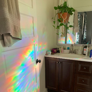 A review image showcasing rainbows dancing on the wall opposite the window where the privacy film is applied