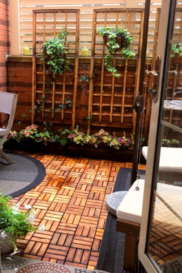 A backyard patio covered with interlocking teak tiles