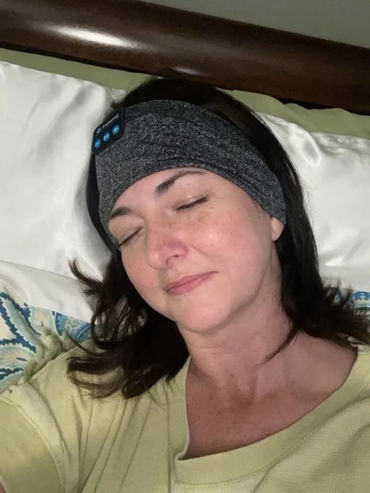 A reviewer wearing the headband while lounging in bed, enjoying a moment of relaxation