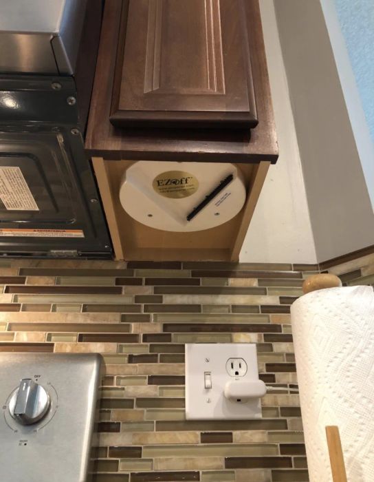 A shot of a reviewer's cabinet's underside, showcasing the lid opener discreetly installed.