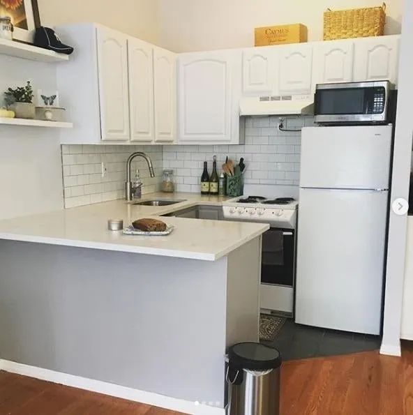 A reviewer's photo showcasing their newly updated kitchen with a sleek white and gray color scheme.