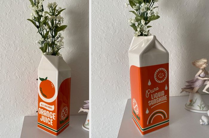 A reviewer’s photo of the vintage orange juice carton vase filled with flowers