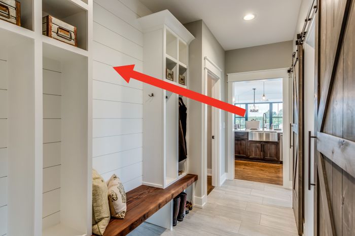 Arrow pointing to white shiplap walls in a corridor