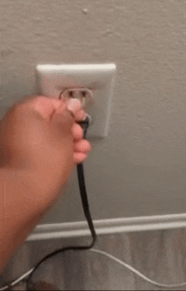 A reviewer inserting a small plastic fitting into an outlet, followed by plugging in a device that stays securely in place.