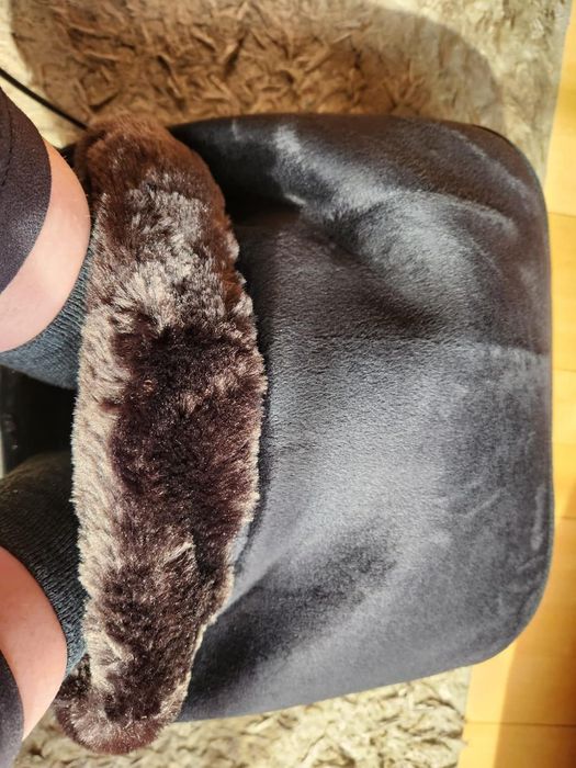 Cozy feet tucked inside a plush, furry foot warmer, offering the perfect comfort for the season's shopping.