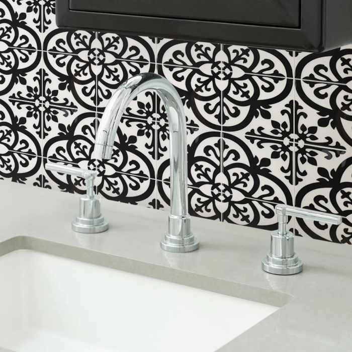 A striking black-and-white mosaic-patterned peel-and-stick tile backsplash enhancing the area behind a bathroom sink.