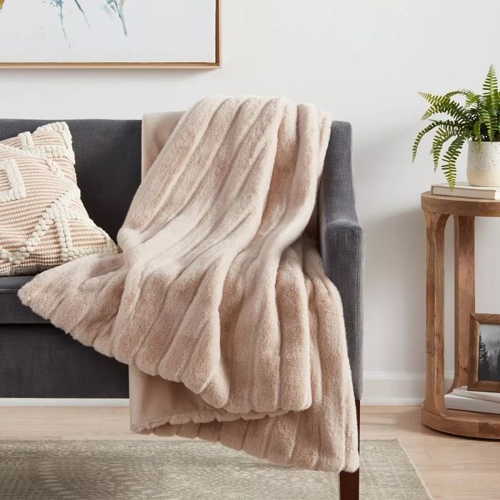 The textured faux-fur throw laid out on a couch, adding a touch of warmth and style