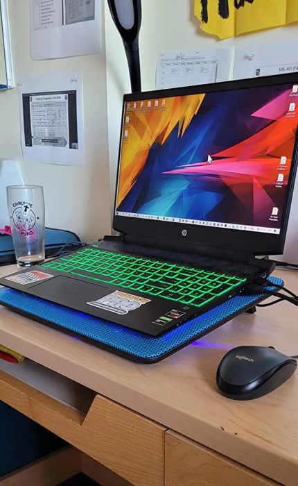 A laptop resting comfortably on a sleek cooling pad.