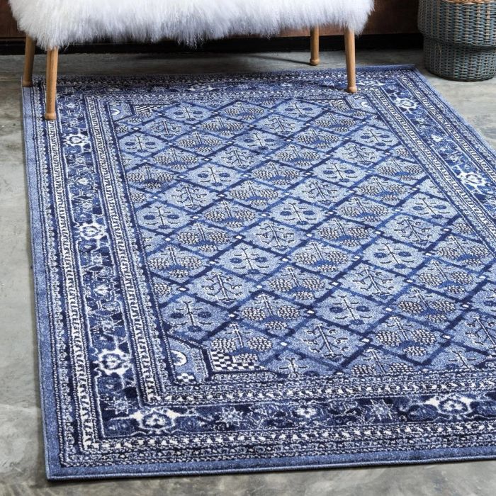 A beautifully patterned rug showcasing a mix of ivory and blue hues, adding elegance and depth to any room.
