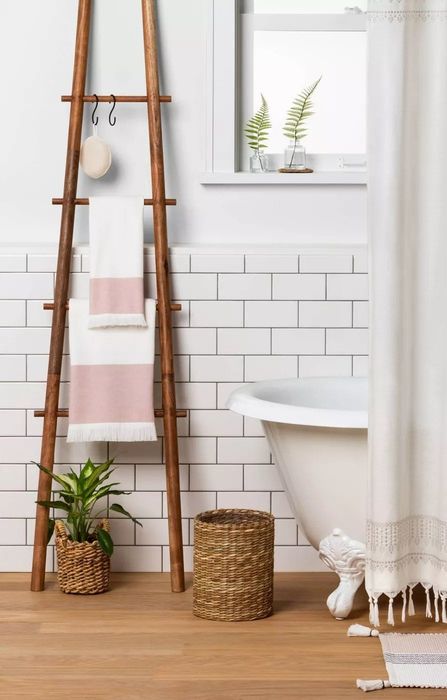 The towel ladder with four rungs, each holding a towel, placed in a bathroom for added convenience and style