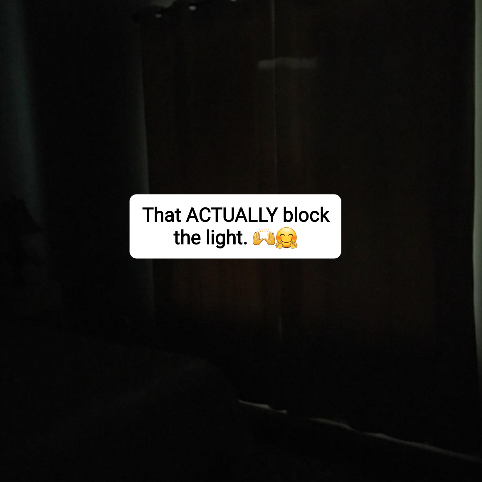 The same reviewer's bedroom with the blackout curtains fully closed, making the room pitch black.