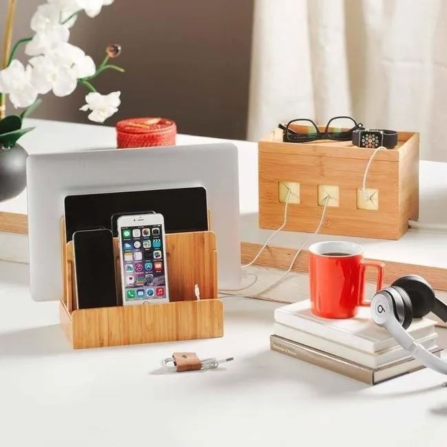 A wooden charging station with three separate slots designed to hold various electronics, such as your phone, iPad, and laptop.