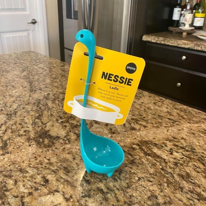 A Nessie ladle with a long neck and sturdy base, standing on a kitchen counter—an irresistible choice for quirky kitchenware lovers.