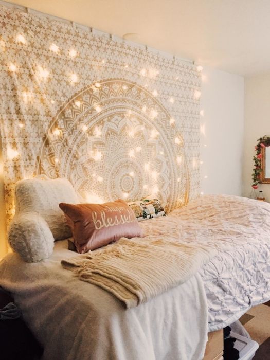 A cozy setup featuring LED string lights cascading down a wall beside a bed.