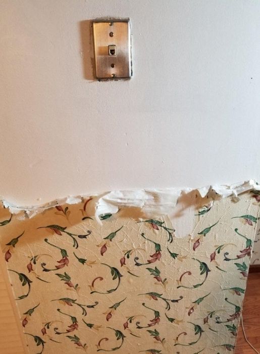 Wallpaper effortlessly coming off the wall after applying the stripping spray