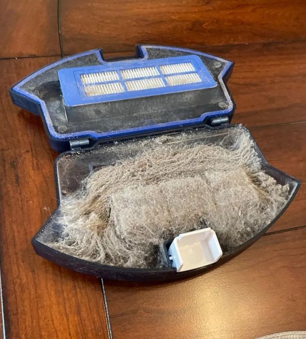 The inside of the robot vacuum filled with dust.