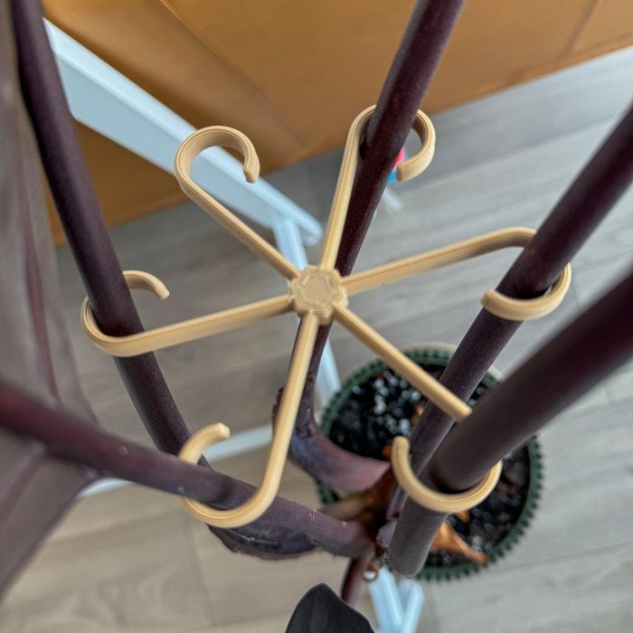 The stem support featuring six curved arms designed to hold a plant stem upright.