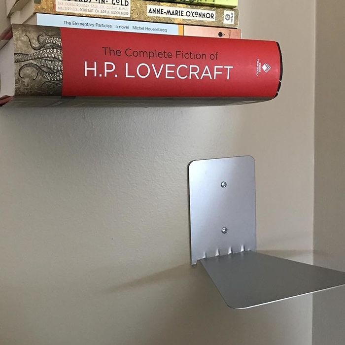 A reviewer’s books placed on one of the floating shelves, while the other shelf remains empty.