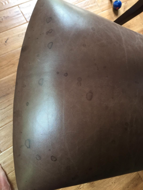 A customer's before: a leather barstool covered in dark stains, dirt, and several noticeable water spots.