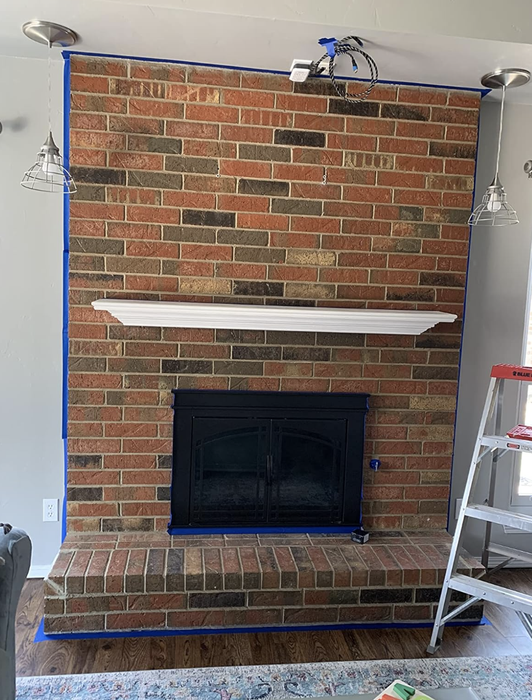 Reviewer's red brick fireplace before the whitewash transformation.