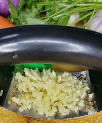Reviewer's garlic press filled with freshly minced garlic