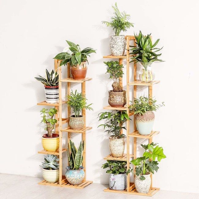 A five-tier and six-tier plant stand crafted from light wood, showcasing potted plants on each tier.