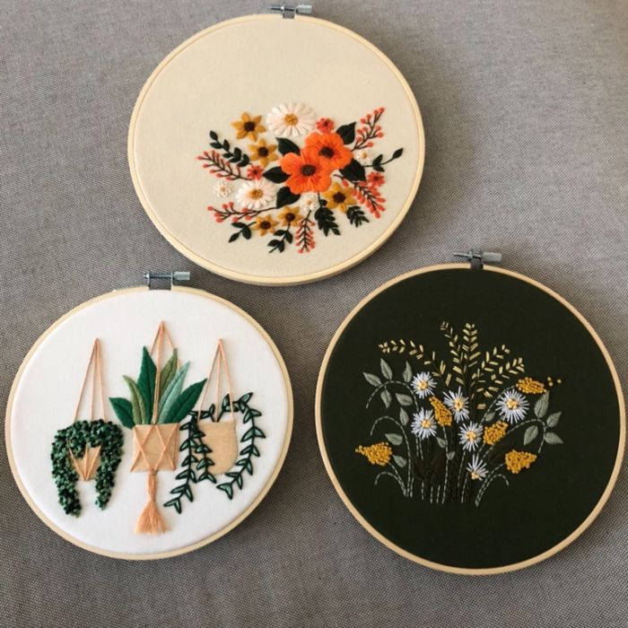 Three beautifully embroidered hoops, each displaying floral and plant motifs, ideal for decorating your home.