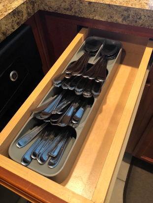 A reviewer's slim drawer neatly organized with a utensil tray, holding all their silverware in place