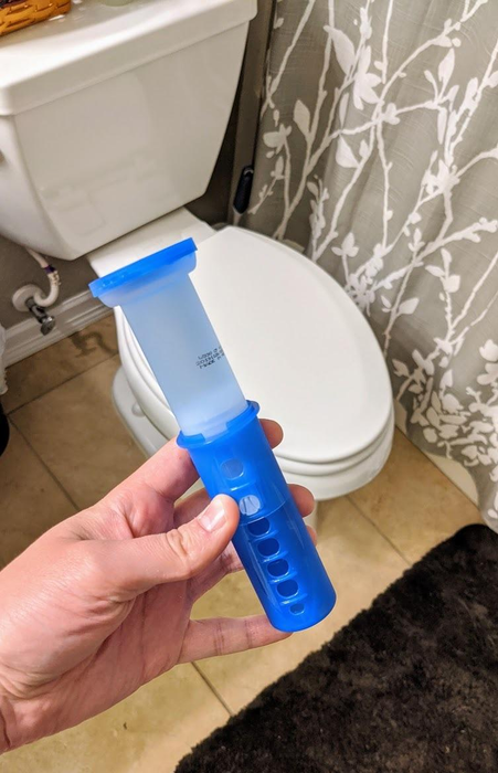 Reviewer holding a Scrubbing Bubbles toilet gel stamp.