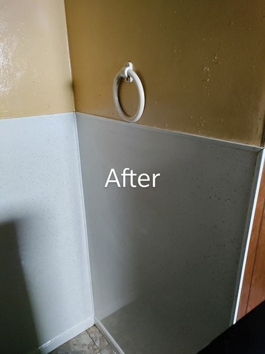 A reviewer's after photo of a bathroom wall that is now spotless, with no visible stains