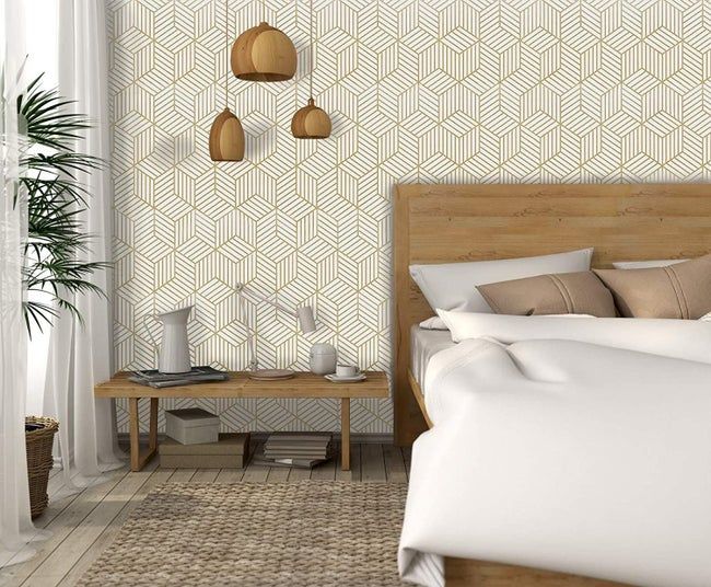 A bedroom featuring gold geometric wallpaper.