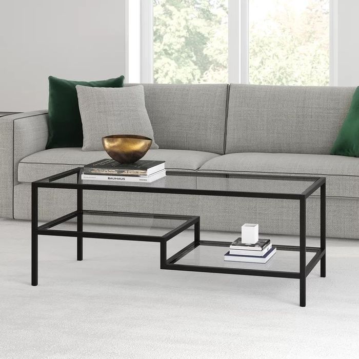 A sleek glass coffee table featuring a sturdy black frame, perfect for adding a modern touch to any living space.