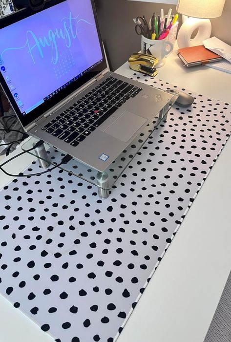 A white desk mat adorned with playful black polka dots.