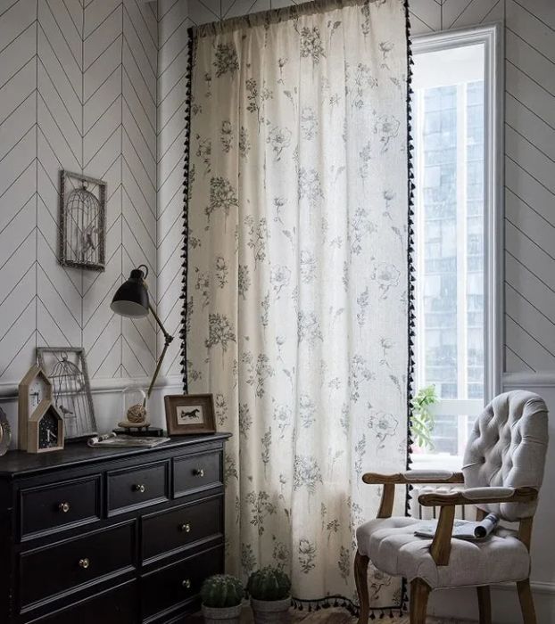 floral curtains with pom-pom trim in a cozy living room setting