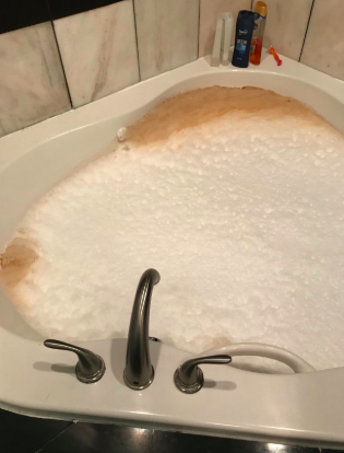 A tub filled with foamy, dirt-laden water.