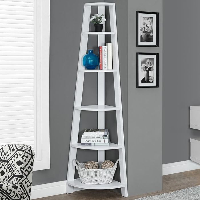 A corner shelf neatly arranged with books, a stylish blue vase, and a woven basket for added charm.