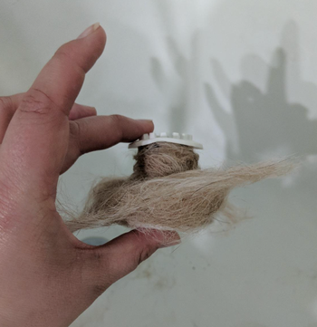 A reviewer's TubShroom filled with long dog hair caught inside