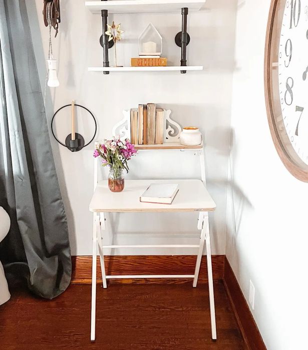 A two-tier desk with a wood top and white metal crossed legs.