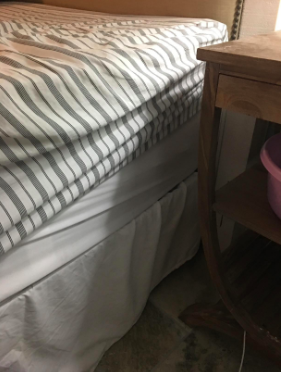 A reviewer’s photo showing a fitted sheet creeping up the side of the mattress, taken before using sheet suspenders.