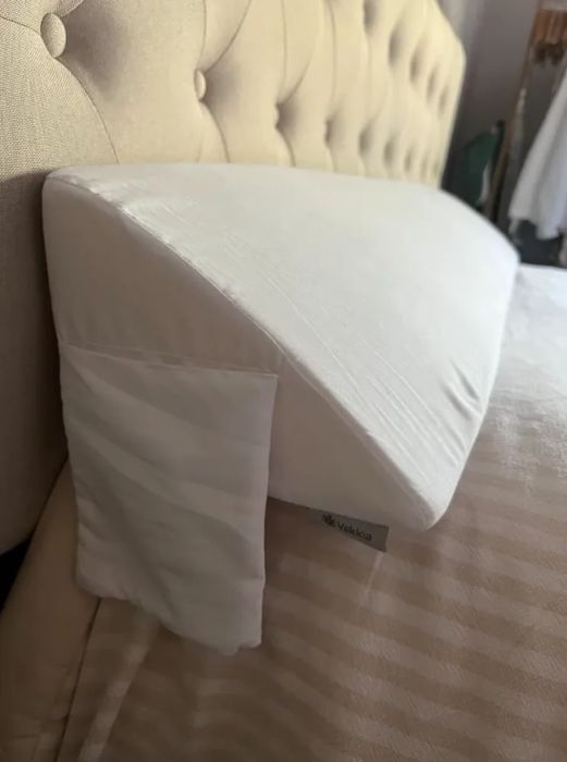A wedge-shaped memory foam pillow with a removable white cover, featuring a Vekkia brand label on the side