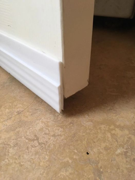 close-up shot from a reviewer showing a white door draft stopper at the bottom of their door