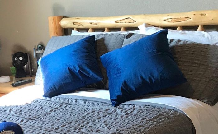A calming scene with blue pillows laid out neatly on a bed.