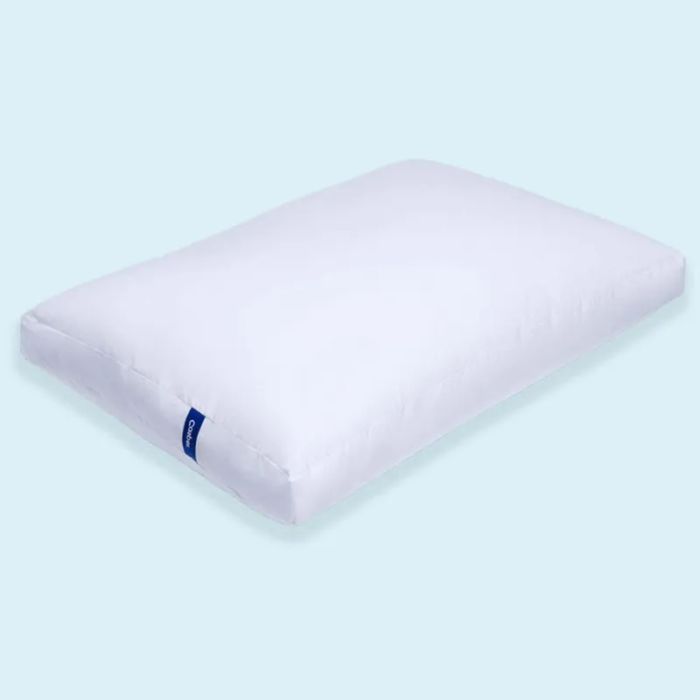 A sleek, white rectangular pillow with a signature blue tag, elegantly displayed against a minimalist background in a featured shopping showcase.