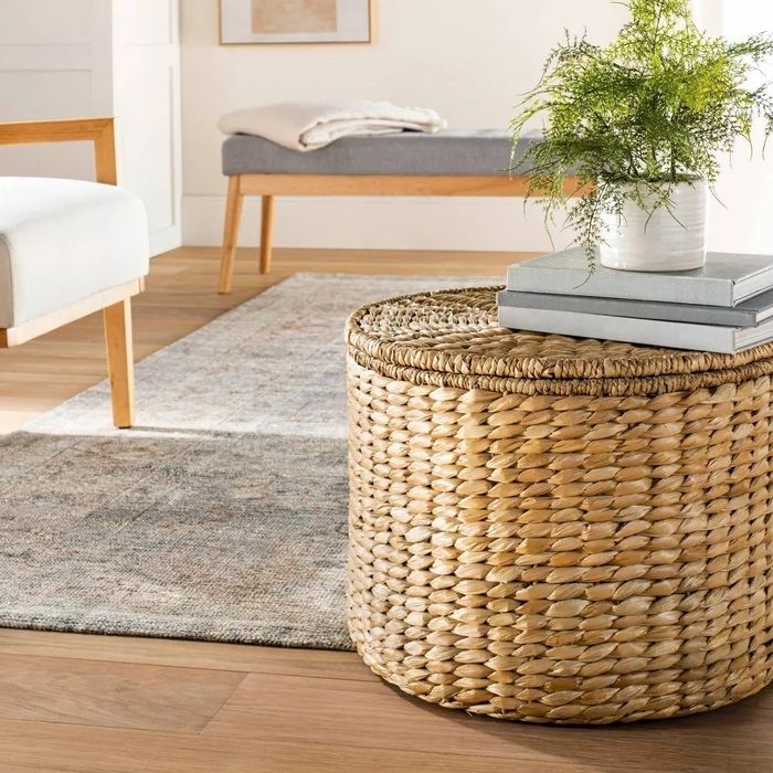 The woven storage ottoman placed in a cozy living room setting